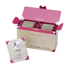 Open box filled with Ippodo gyokuro tea bag packets with magenta accents, alongside a single gyokuro packet in front.