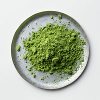 Loose bright green Ippodo Tea Nodoka Japanese matcha powder on silver plate on white table