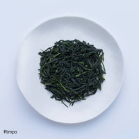 White plate of dark green loose leaf Ippodo Tea Rimpo gyokuro tea leaves on white table