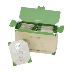 Open box filled with Ippodo sencha tea bag packets with green accents, alongside a single sencha packet in front.