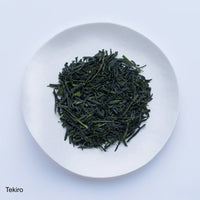 Loose leaf dark green rolled dried Ippodo Tekiro Gyokuro premium Japanese green tea on white plate on white table