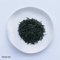 Loose leaf darker green rolled dried Ippodo Tenka-Ichi Gyokuro premium Japanese green tea on white plate on white table