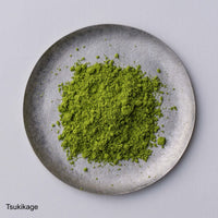 Bright green loose Japanese Ippodo Tea Tsukikage matcha powder on grey plate on white table