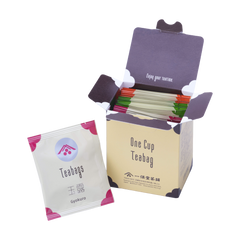 Open box of Ippodo One Cup Teabag packets with an individual gyokuro tea bag packet in front on a white background.