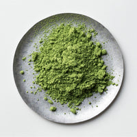 Loose green finely ground milled Japanese Ippodo Organic Matcha tea powder on silver plate on white table