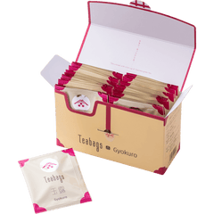 Open cream box containing 25 individually wrapped Gyokuro Teabags beside one teabag packet with pink corners and Ippodo logo