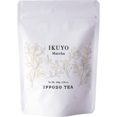 White 100 gram bag of Ippodo Tea Ikuyo matcha powder for with line drawing of gold and green leaves of the tea plant