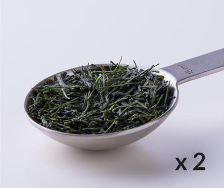 Silver tablespoon filled with dried rolled Ippodo Sencha premium Japanese green tea leaves with 