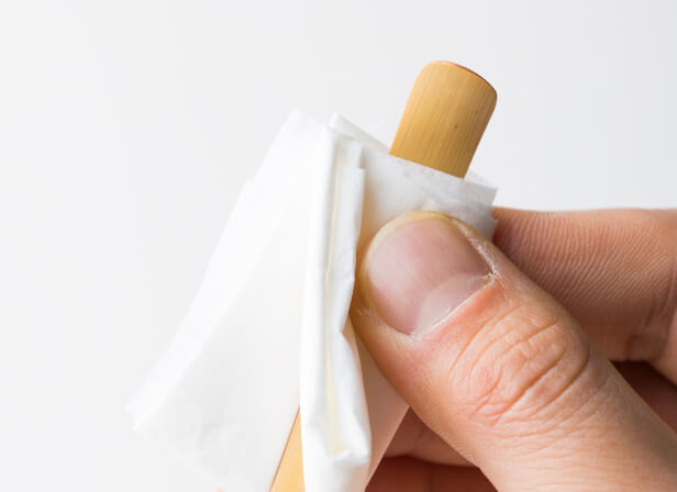 Tissue sticking out of plain turquoise tissue box against bright yellow background