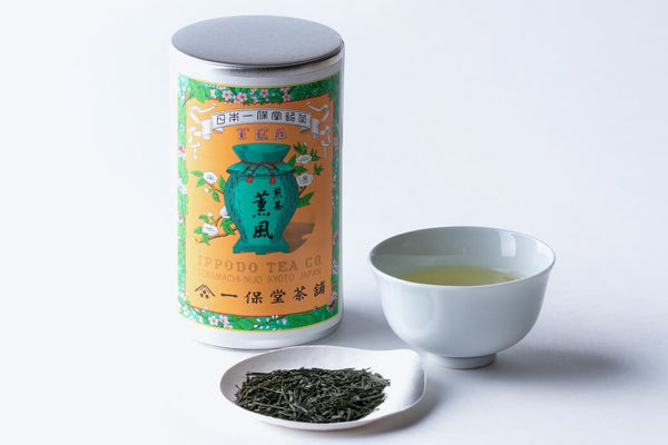 Iconic orange can of Ippodo Kaboku with porcelain Japanese teacup and looseleaf Sencha on small white plate