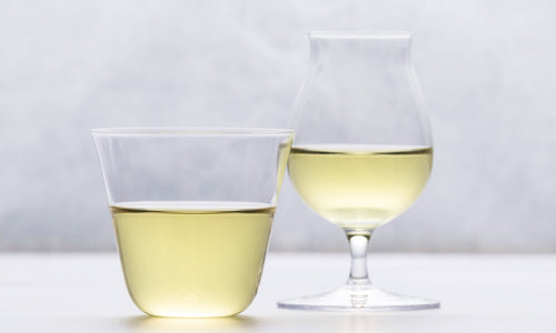 Cold brewed sencha in a regular glass and wine glass with a gray background.
