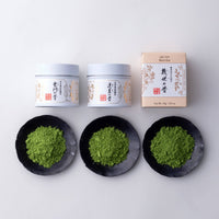 Comparison of each each variety of matcha tea in set, Ummon, Horai and Ikuyo, with packaging beside samples on black dishes