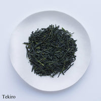 White plate of dark green loose leaf Ippodo Tea gyokuro tea leaves on white table labeled Tekiro