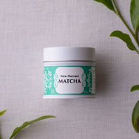 Unopened tin of New Harvest Matcha with iconic Ippodo tea pot and floral design in bright green against linen background