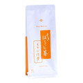 A tall white pouch of Ippodo Tea Stems Hojicha (80g / 2.82 oz) featuring a bright orange vertical banner with Japanese calligraphic text for "Kuki Hojicha". - thumbnail 1