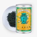 Ippodo Tea Co. tea canister with green tea leaves on a white plate and white background