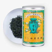 Ippodo Tea Co. tea canister with green tea leaves on a white plate and white background