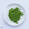 Bright green loose Japanese Ippodo Tea Ikuyo matcha powder on white plate on white table