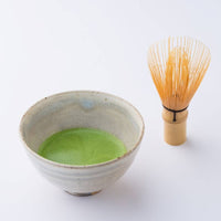 Korean artisan-made Chasen 80-tip bamboo matcha whisk tea utensil with green matcha tea in ceramic tea bowl