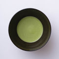 Green usucha straight Ippodo New Harvest Matcha with light green frothy bubbles on surface in black colored ceramic tea bowl