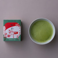 Ippodo Tea Koma-Mukashi (New Year's Matcha 2026) box next to a white bowl of prepared, frothy matcha tea.