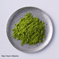 Close-up overhead view of vibrant green Ippodo Tea Koma-Mukashi (New Year's Matcha 2026) powder on a small, round plate.