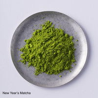 Close-up overhead view of vibrant green Ippodo Tea Koma-Mukashi (New Year's Matcha 2026) powder on a small, round plate.