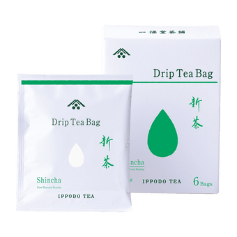 White package of individually wrapped Shincha New Harvest teabag in front of white and green box of teabags