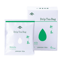 White package of individually wrapped Shincha New Harvest teabag in front of white and green box of teabags