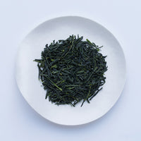 Loose leaf dark green rolled dried Ippodo Tekiro Gyokuro premium Japanese green tea on white plate on white table
