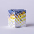Tea box with blue and yellow geometric pattern, flowers and Japanese and English text on a light gray background