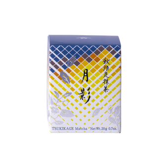 Front view of unopened tea box with blue and yellow geometric pattern, flowers and Japanese and English text