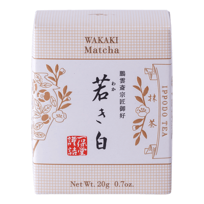 New unopened beige box of Ippodo Tea Co. Wakaki matcha with Japanese characters and gold leaf flowers embossed on white