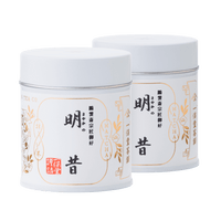 Two white tin cans of rich bestseller Sayaka matcha by Ippodo Tea with Japanese characters and gold leaf