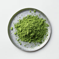 Loose bright green Ippodo Tea Nodoka Japanese matcha powder on silver plate on white table