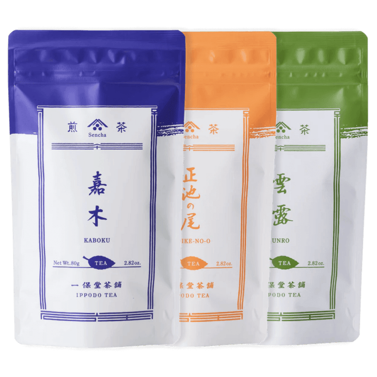 Three resealable 80g packages of Ippodo sencha tea colored indigo, orange and green respectively overlapping each other