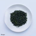 Ippodo Tea Rimpo gyokuro sample depicting loose dark blue green rolled futsumushi tea leaves on white plate on white table 