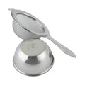 Stainless steel Chakoshi tea strainer with Ippodo Tea seal on handle beside upside-down receiving bowl with logo on underside