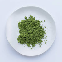 Lighter green loose Japanese Ippodo Tea Hatsu matcha powder on white plate on white table