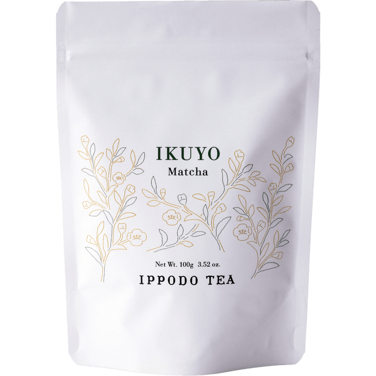 White 100 gram bag of Ippodo Tea Ikuyo matcha powder for with line drawing of gold and green leaves of the tea plant