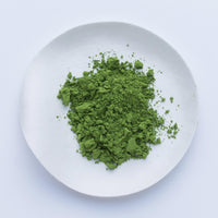 Bright lush green loose Japanese Ippodo Tea Sayaka matcha powder on white plate on white table