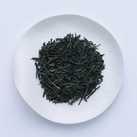 Loose leaf dark green rolled dried Ippodo Tekiro Gyokuro premium Japanese green tea on white plate on white table