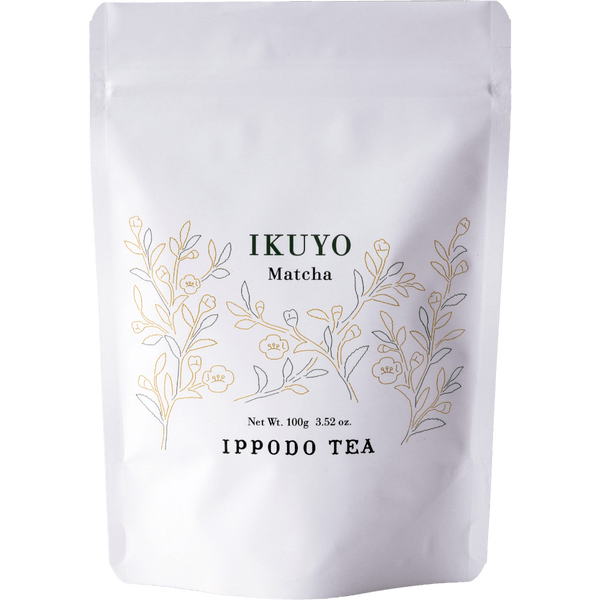 White 100 gram bag of Ippodo Tea Ikuyo matcha powder for with line drawing of gold and green leaves of the tea plant