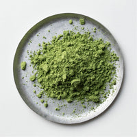 Loose bright green Ippodo Tea Nodoka Japanese matcha powder on white plate on white table