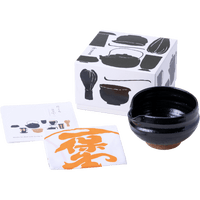Black matcha tea bowl with serving spout alongside fukin tea cloth, illustrated instruction kit and tea utensil decorated box