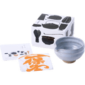 White matcha tea bowl with serving spout alongside fukin tea cloth, illustrated instruction kit and tea utensil decorated box