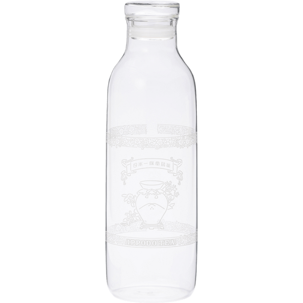 A clear glass bottle with a narrow neck and wide body. It appears empty and has some etched or printed design on its surface, though the details aren't clearly visible. The bottle has a simple, cylindrical shape typical of water or juice bottles, with a slight lip at the top where a cap would typically be placed. The glass is transparent and clean.