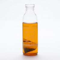 Embossed glass 1-litre carafe containing Ippodo's Mugicha barley tea one-pot teabags and golden yellow cold brew summer tea