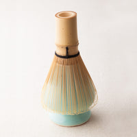 Light pastel turquoise blue Ippodo Tea ceramic stand supporting bamboo Chasen 80-tip matcha whisk