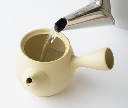 Pouring hot water from silver kettle into ivory Tokoname-yaki ceramic Ippodo Tea Co. Japanese kyusu teapot